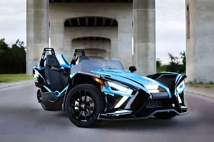 Futuristic three-wheeled vehicle under a bridge.